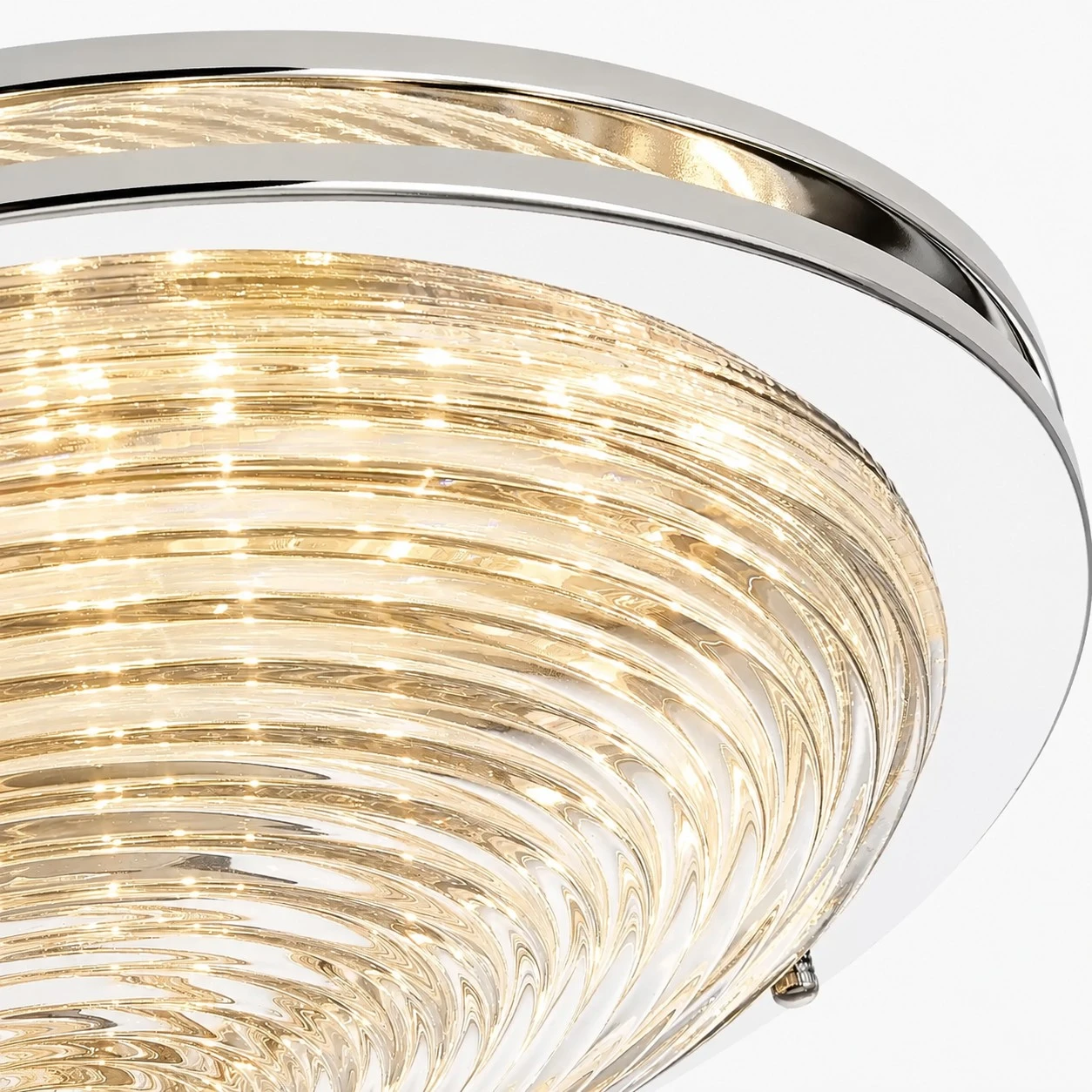 Close view of rippled glass shade and chrome rim on the ceiling light