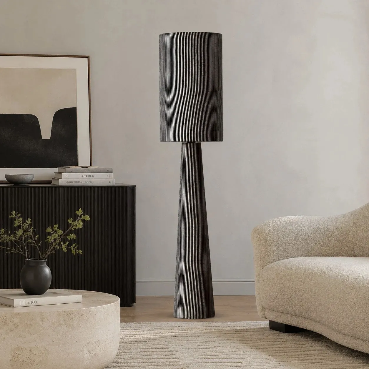 Gray striped floor lamp near a console and lounge chair
