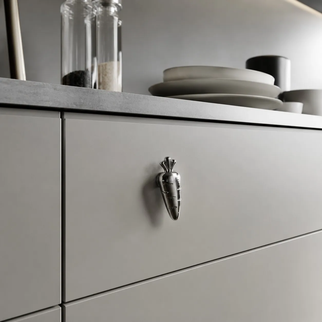 Chrome silver carrot knob on a gray drawer