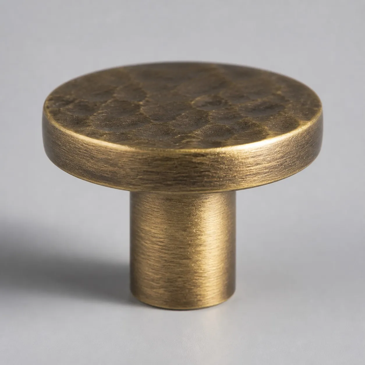 Side view of round flat antique brass cabinet knob